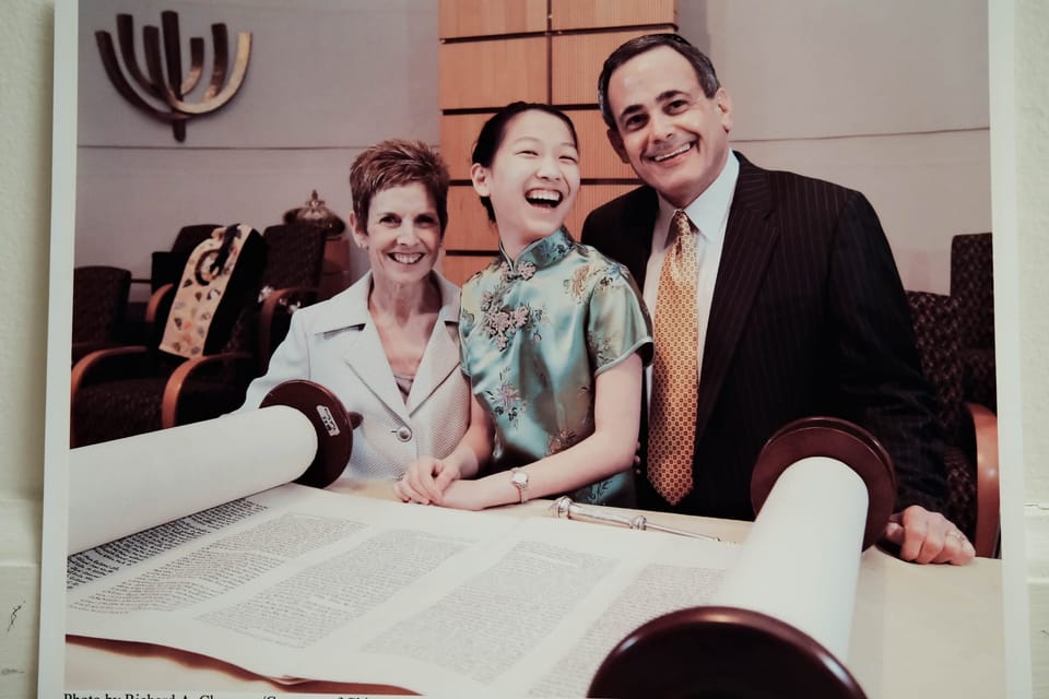 A family stands at the Torah.